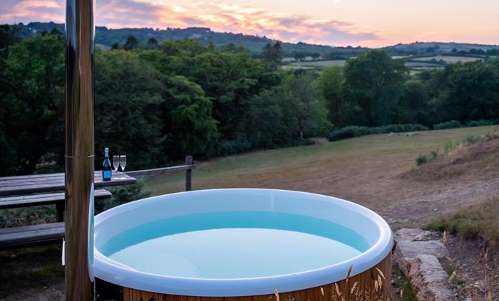 The view of the valley at sunset with a wood fire hot tub in the foreground